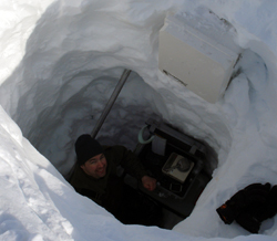 Researcher Joel Bailey measures the density of the snow in this snow pit to determine the amount of snow in the drift and the water equivalent of the snow drift.